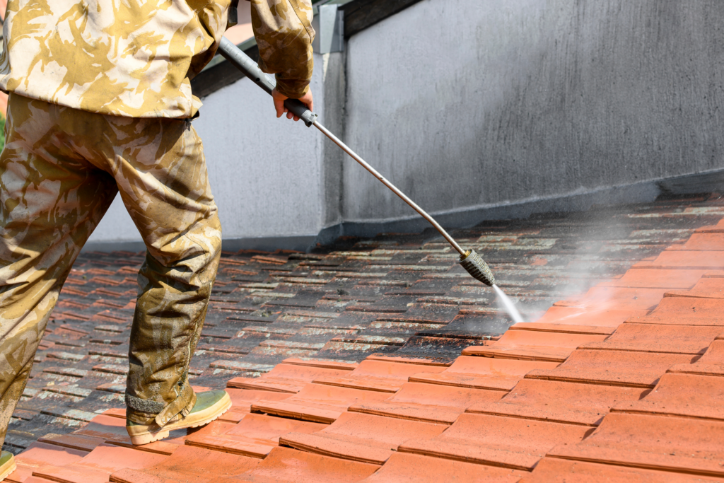 Man performing soft washing on home-exteriors